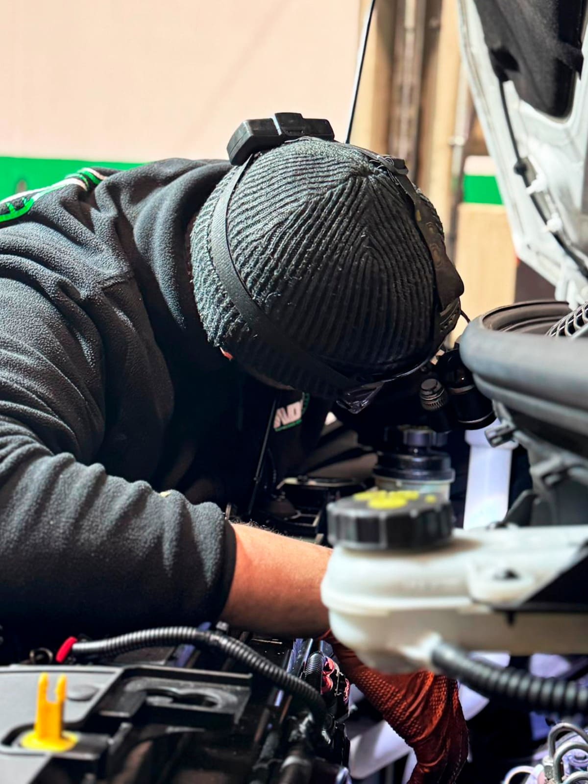 Técnico de ADS Servicios Integrales realizando reparación mecánica con linterna frontal en el taller de Noblejas, Toledo.